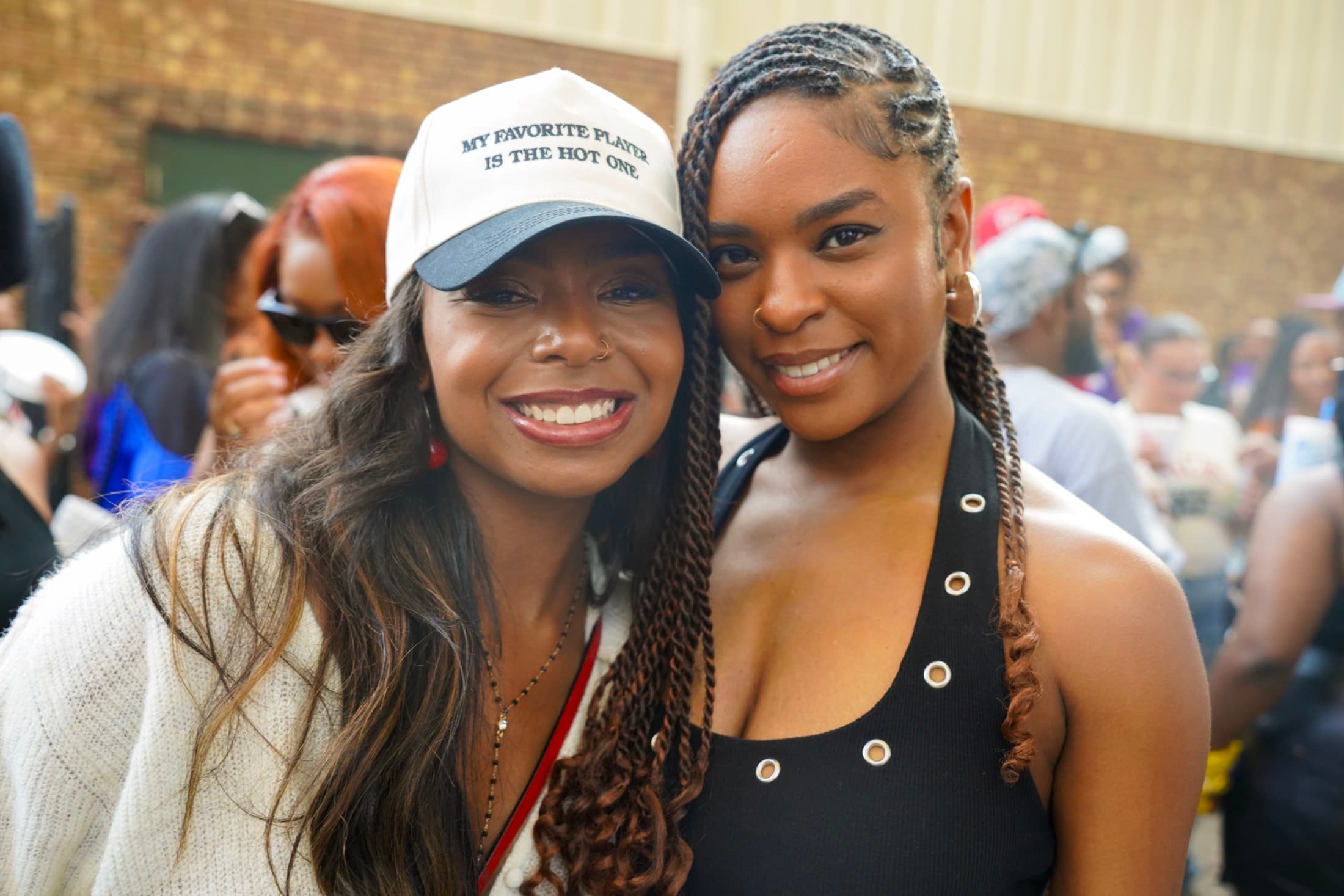 Two women smiling together at an outdoor social gathering